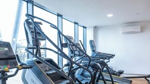 A gym with treadmills, a rowing machine, and a stationary bike. - Luxury Waterfront 2BR - Free Gym Access & Parking (Stretford)