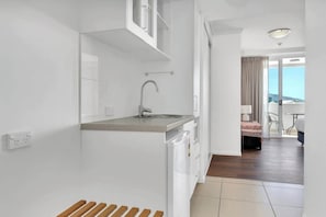 Une cuisine moderne dotĂ©e dâun Ă©vier intĂ©grĂ©, dâun coin repas avec une table et des chaises, et offrant une vue sur lâextĂ©rieur.
