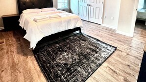Une chambre à coucher avec un lit, un ventilateur de plafond, une fenêtre et une porte.