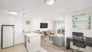 Un appartement moderne comprenant une cuisine, un coin repas, un salon et un balcon.