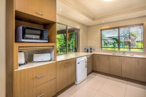 Una cucina moderna con mobili in legno, un forno a microonde, un tostapane e una lavastoviglie.