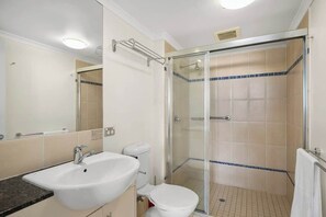A bathroom with a sink, toilet, and glass-enclosed shower. - Resort-Style Cityview Getaway in Perfect Location (Cairns)