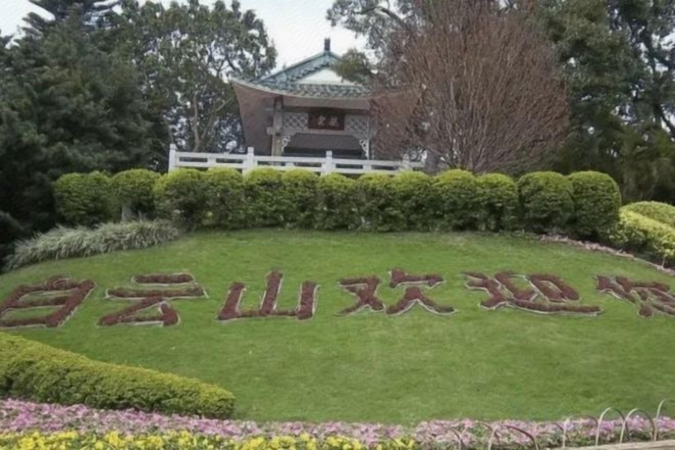 A landscaped area with a traditional pavilion and neatly trimmed bushes.