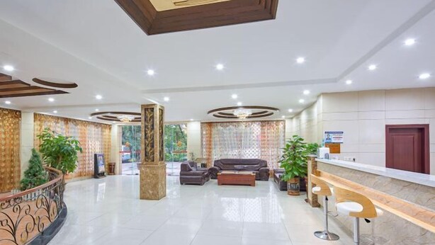 A spacious lobby with a reception desk, seating area, and decorative plants. - Guangzhou Jintai Hotel (Jianggao Store) (Guangzhou)