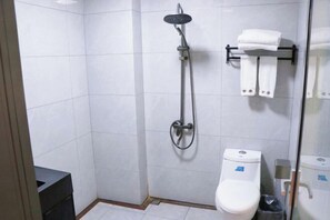 Ein modernes Badezimmer mit Dusche, Toilette und Handtuchhalter.