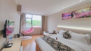 A hotel room with a bed, a desk with a computer, a hanging chair, and a large window. - Guangzhou Jintai Hotel (Jianggao Store) (Guangzhou)