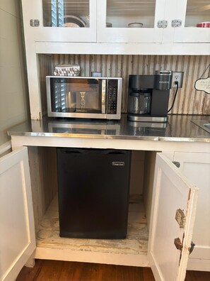 Modern kitchen with stainless steel microwave, coffee maker, and refrigerator.
