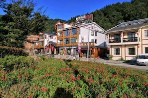 A hotel with multiple floors, a visible restaurant, and a parking area.