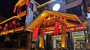 A hotel entrance with a sign in Chinese characters, a staircase, and red lanterns. - Mengxiyuan Resort Hotel (Zhangjiajie)