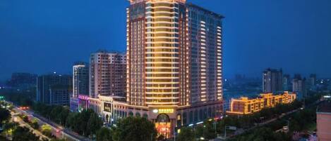 A high-rise hotel with multiple floors, a prominent entrance, and a surrounding urban environment.