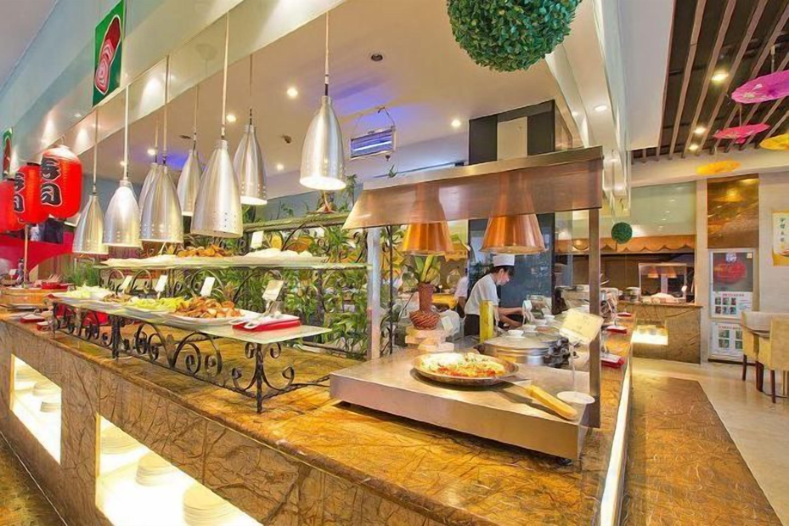 A buffet area with multiple food stations and overhead lighting.