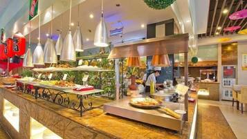 A buffet area with multiple food stations and overhead lighting.
