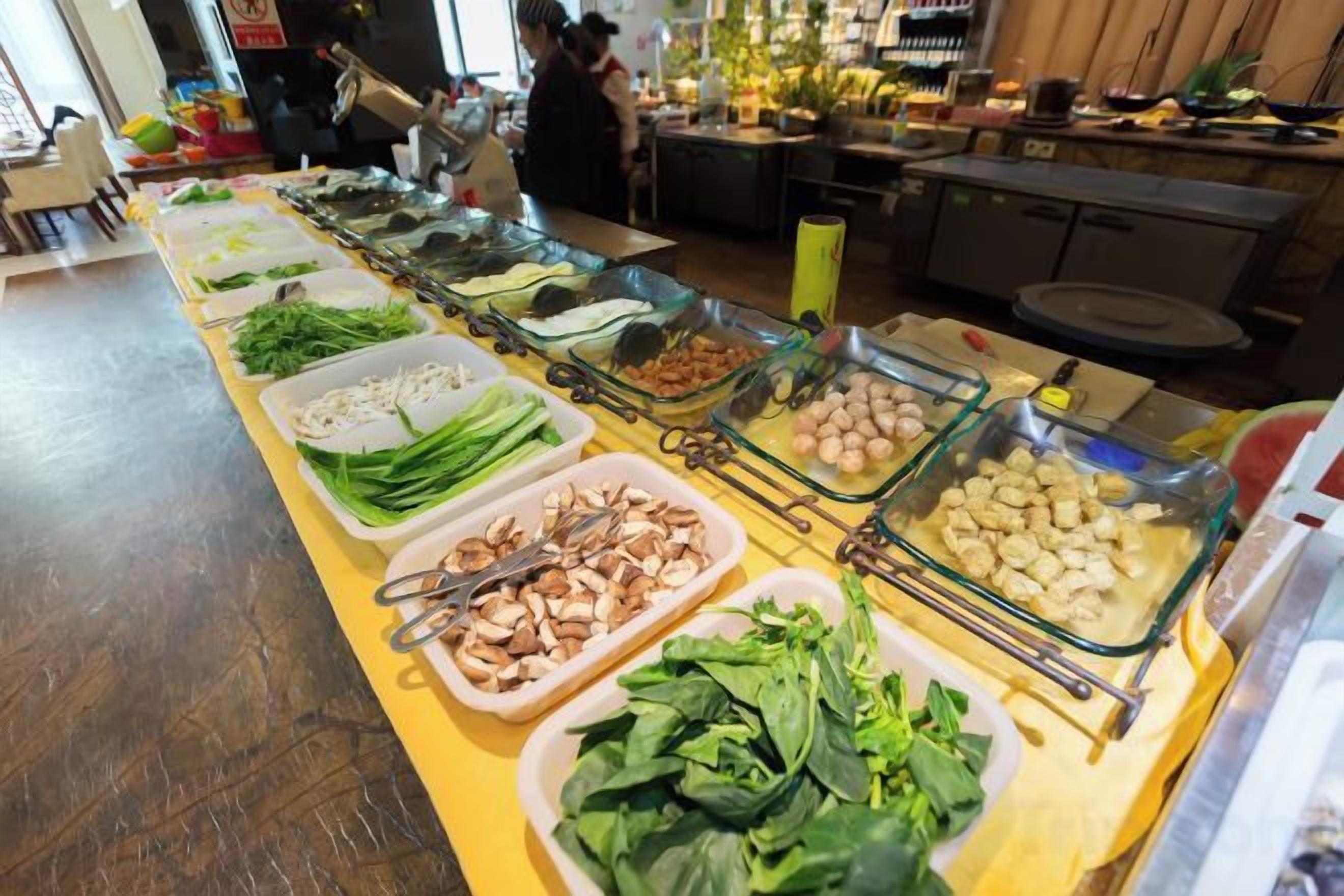 A buffet with various food items arranged in glass containers.