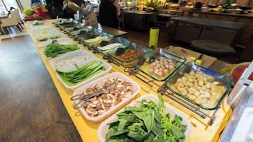 Un bufé con diversos alimentos dispuestos en recipientes de vidrio.