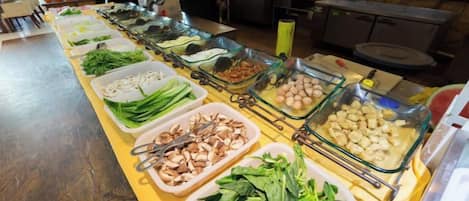A buffet with various food items arranged in glass containers.