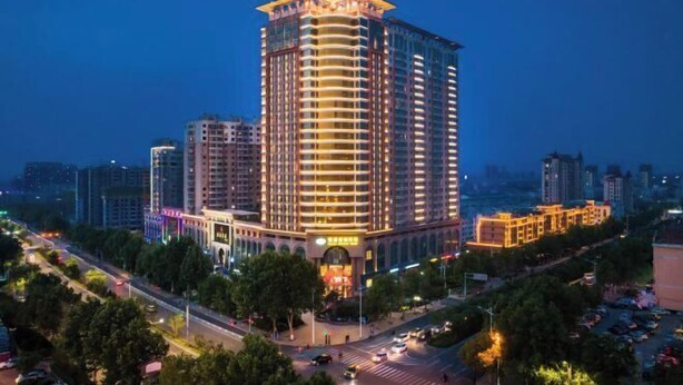 A high-rise hotel with multiple floors, a prominent entrance, and a surrounding urban environment. - Jinan Zhangqiu Inzone Garland Hotel (Jinan)