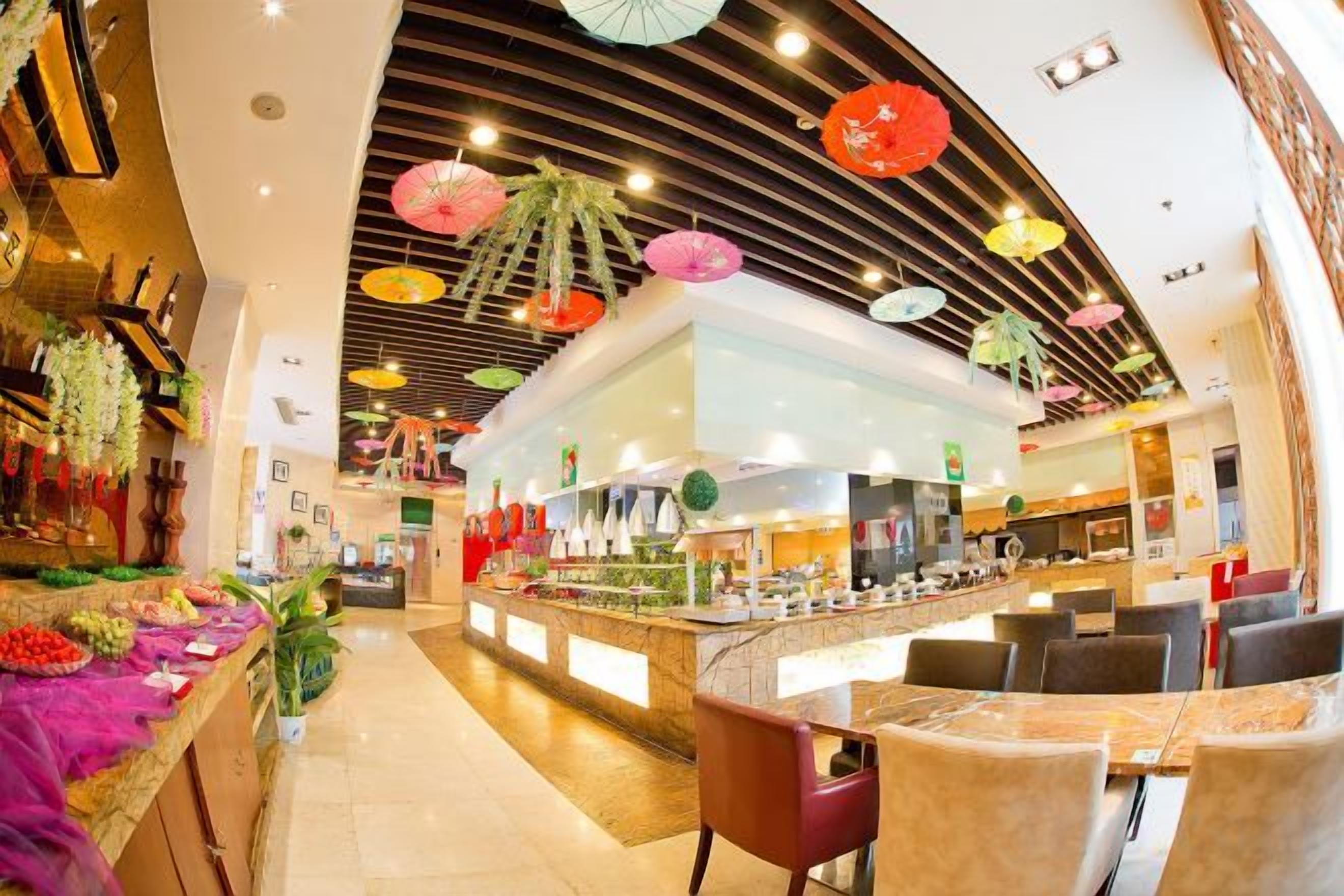 A restaurant with a central counter, seating area, and decorative umbrellas.