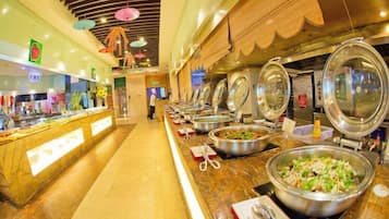 A buffet area with multiple food stations, a long counter, and a person in the background.