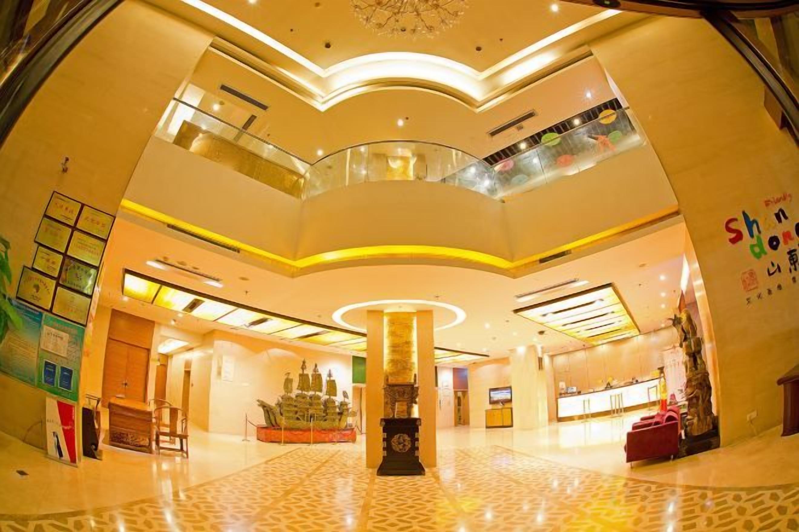 A spacious atrium with a central column, multiple levels, and a glass railing.