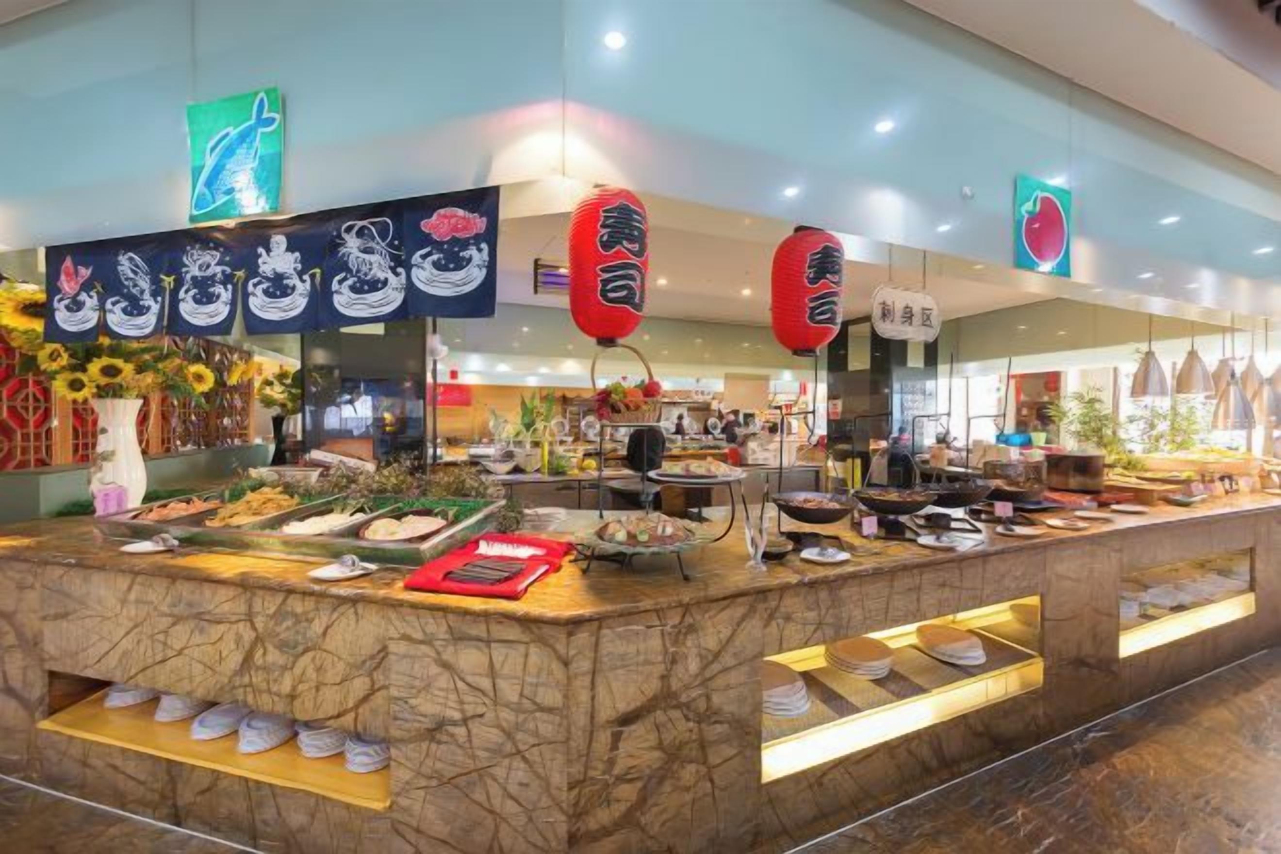 Un comptoir où sont présentés divers plats, avec une pancarte indiquant qu’il s’agit d’un bar à sushis.