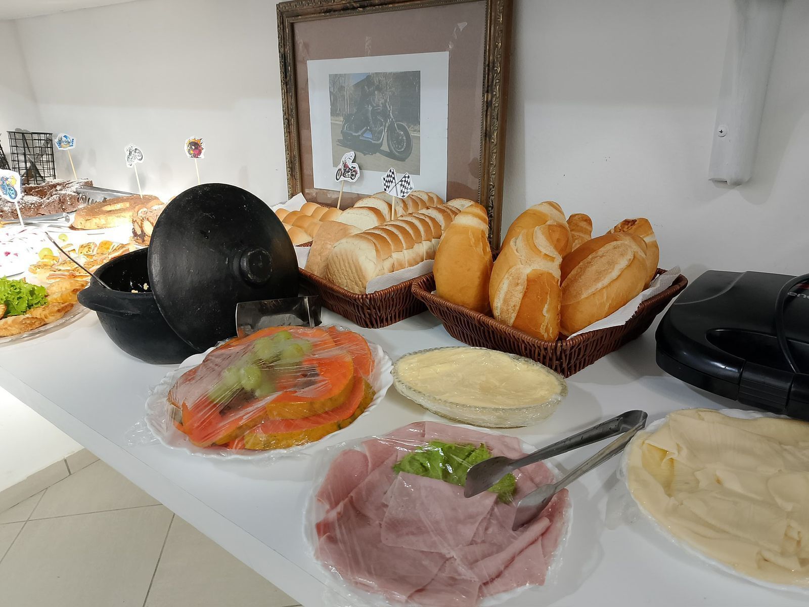 A buffet table with various food items, including bread, meat, and a cake.