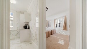 A spacious room with a marble floor, a large window with curtains, and a bed with a beige carpet. - 3 Bedroom Apartment Steps from Piccadilly Circus! (London)