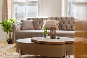 A living room with a round coffee table, a sofa, and a potted plant.