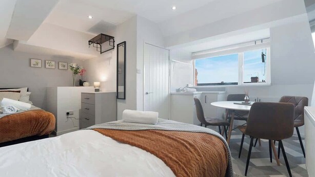 A modern hotel room with two beds, a desk, a chair, and a window with a view. - Central Darlington Sleeps 8 with WiFi and Parking (Darlington)