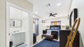 A bedroom with a bed, bedside table, and a ceiling fan.