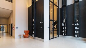 Eine moderne Lobby mit Sitzgelegenheiten, einer Treppe und einer Auswahl dekorativer Gegenstände.