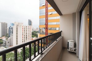 A balcony with a metal railing, a window with a curtain, and a white air conditioning unit labeled 'Philco' on the wall. - Today Pinheiros R (Sao Paulo)