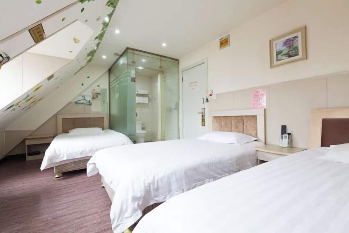 A hotel room with two beds, a staircase, a mirror, and a framed picture on the wall.