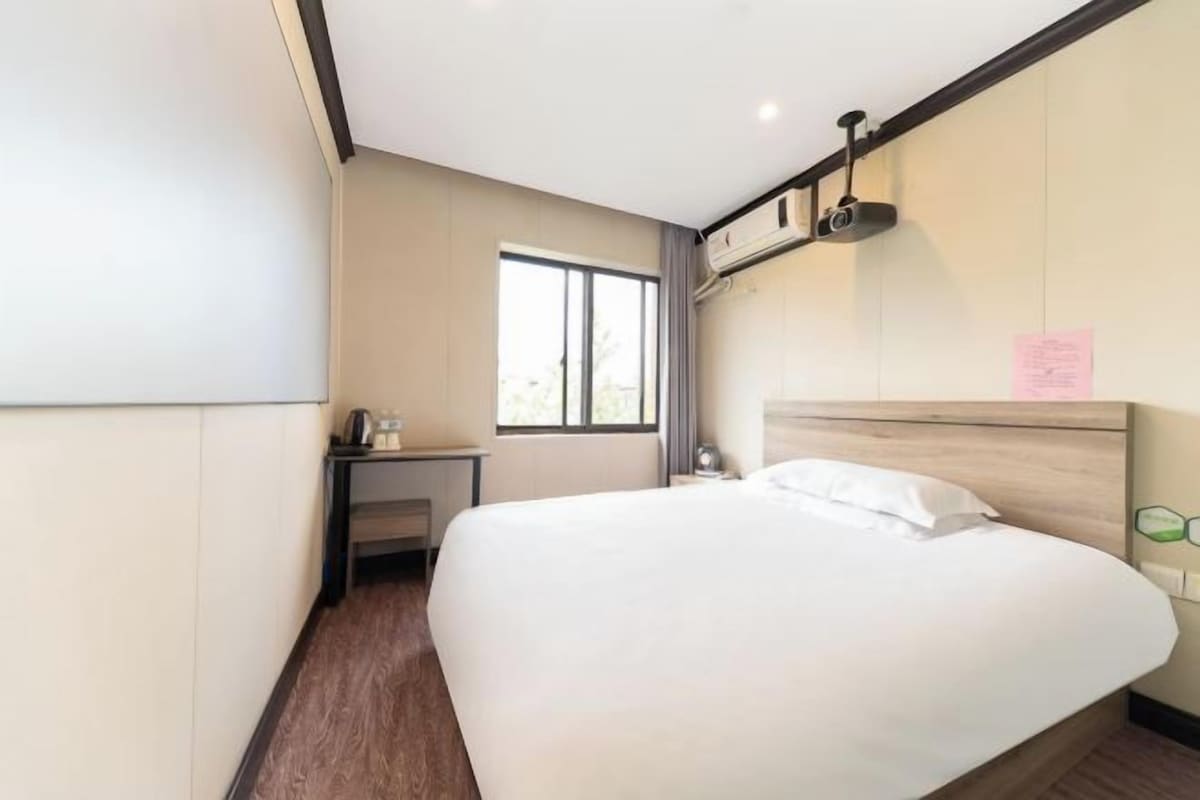 Una camera d'albergo con un letto grande, una scrivania e una finestra.