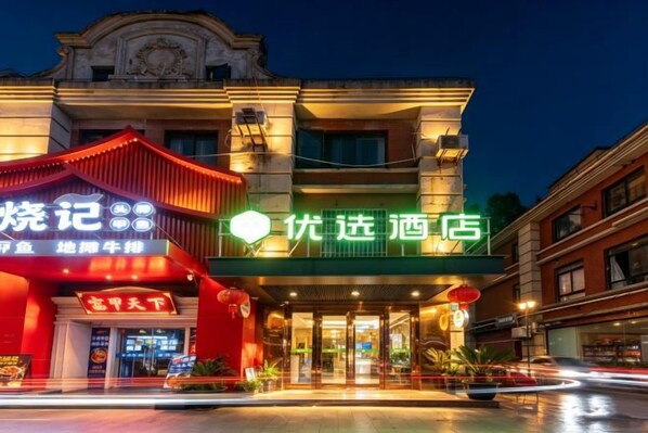 A hotel with a traditional architectural style, featuring a prominent entrance and signage.