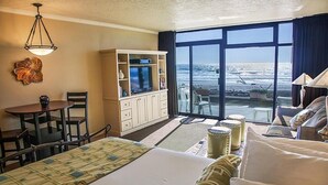 Habitació d'hotel amb llit, escriptori, televisió i vista a l'oceà.