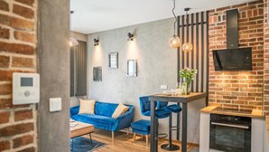 A modern kitchen with a brick wall, a built-in oven, and a TV mounted above it.