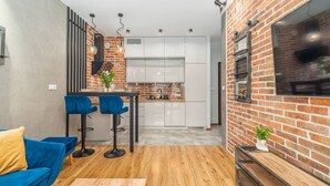 A modern living room with a blue sofa, a coffee table, and a brick accent wall.