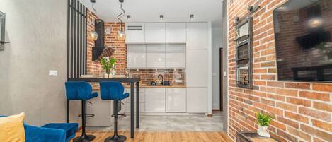 Een koelkast, een oven, een kinderstoel, kookgerei, borden en bestek