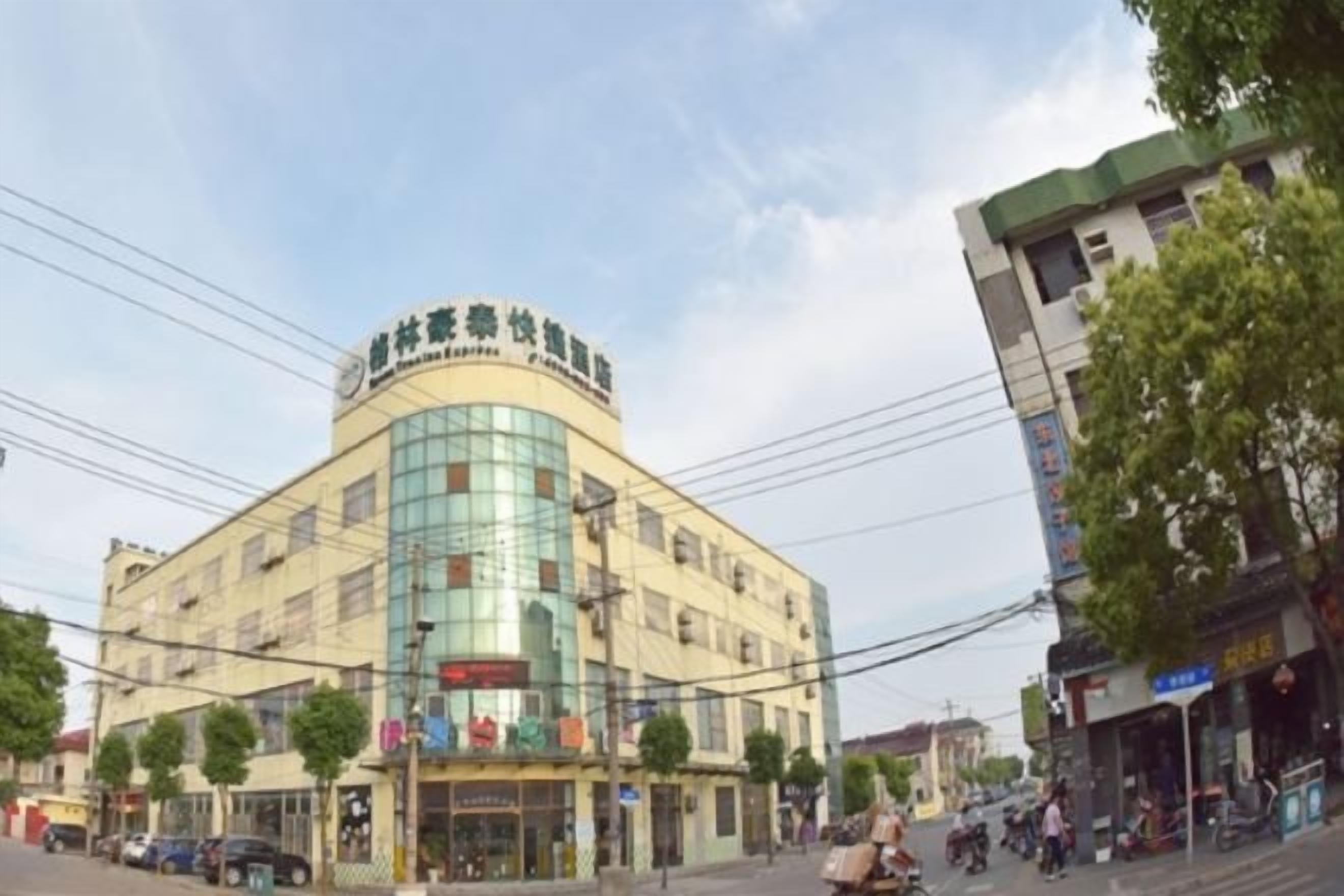 Un edificio de varios pisos con fachada curva, varias tiendas a nivel de calle y una entrada visible.