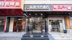 A hotel entrance with a reception desk, glass doors, and a staircase leading up to the entrance. - Jiting E-sports Hotel (Wujiaochang Shanghai Sports University Branch) (Shanghai)