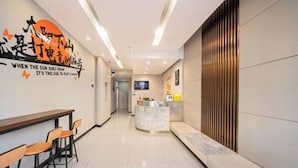 A modern hotel lobby with a reception desk, seating area, and a wall with a motivational quote. - Jiting E-sports Hotel (Wujiaochang Shanghai Sports University Branch) (Shanghai)
