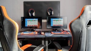 A gaming setup with two monitors, a keyboard, and two gaming chairs. - Jiting E-sports Hotel (Wujiaochang Shanghai Sports University Branch) (Shanghai)
