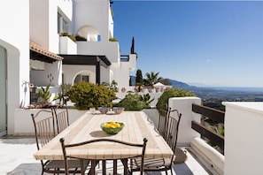 A terrace with a table and chairs, surrounded by plants and a view of the landscape. - Mairena 23 - Sea view apartment (Ojen)