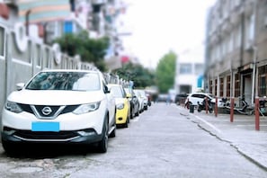 A street lined with parked cars and buildings. - Colorful Art Hotel Shanghai (Shanghai)