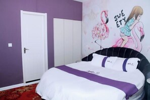 A bedroom with a bed, a door, and a wall with a floral and flamingo illustration. - Colorful Art Hotel Shanghai (Shanghai)