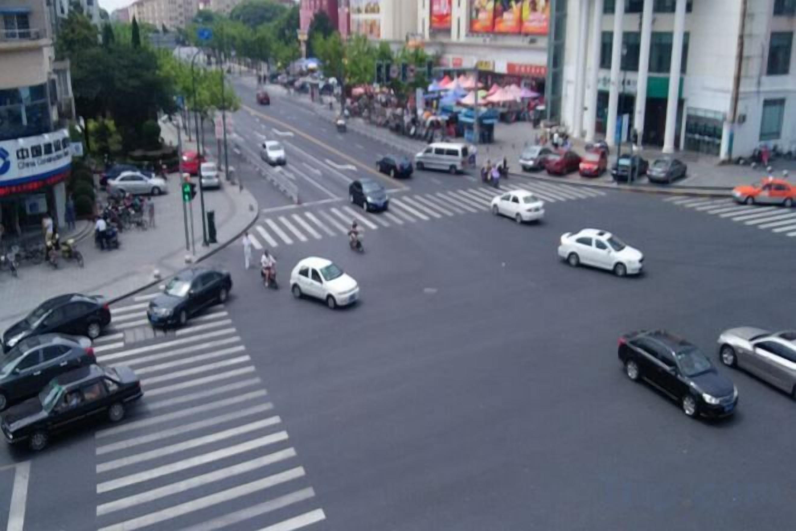 A busy urban intersection with multiple lanes and vehicles.