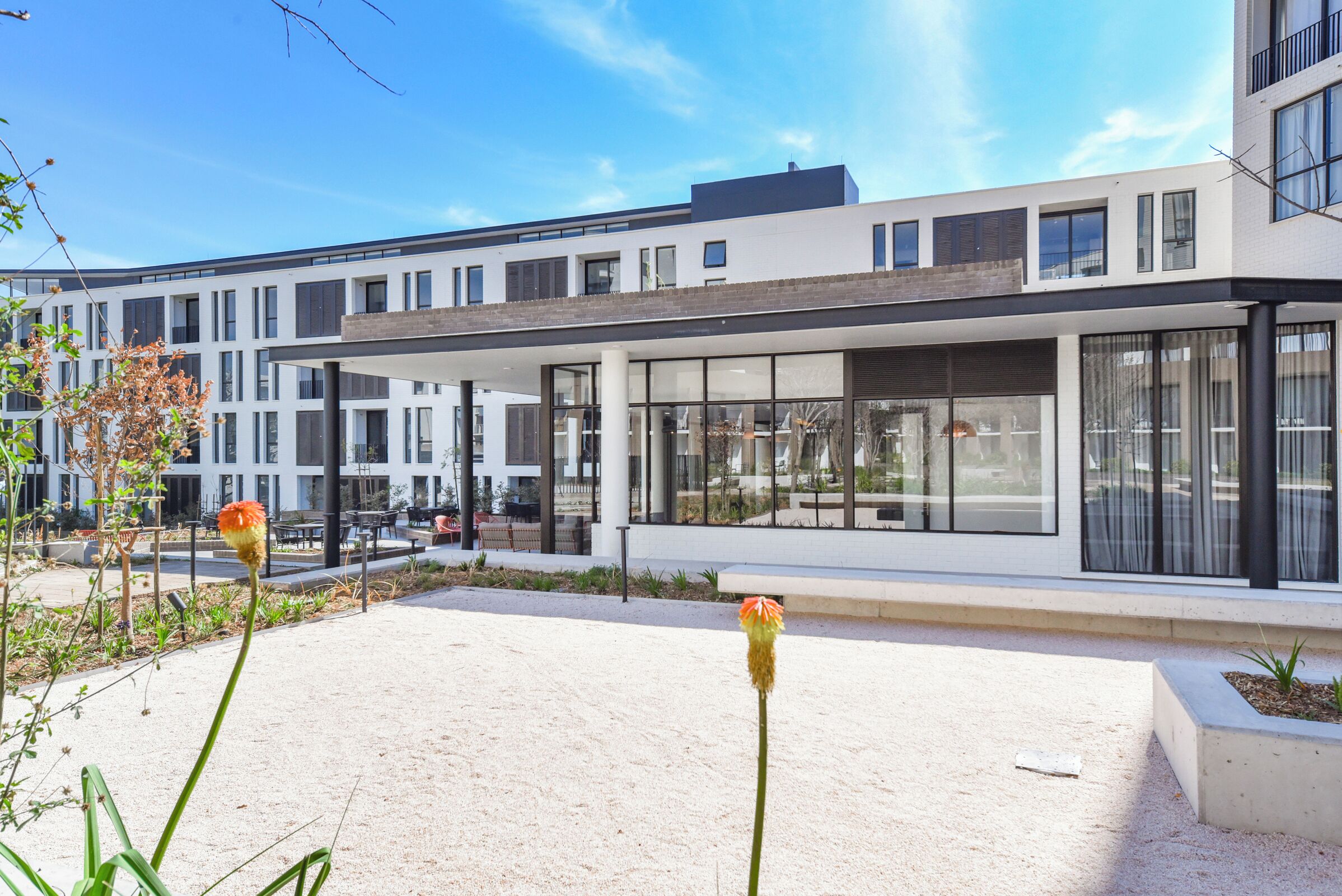 Een modern gebouw met grote ramen en een overdekt terras.