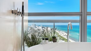 A bathroom with a bathtub, a shower, and a view of a cityscape and beach. - The Setai Private Luxury Residences (Miami Beach)