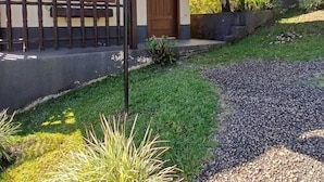 Un bâtiment à deux étages, doté d’un toit en pente, d’une façade en bois et d’une allée gravillonnée.
