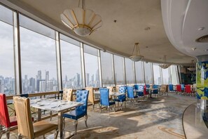 A restaurant with high ceilings, large windows, and a city view. - Ramada Plaza by Wyndham Tian Lu Hotel Wuhan (Wuhan)